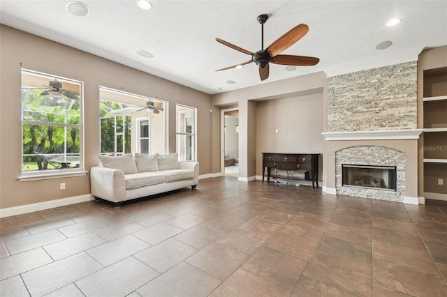 tiled living area featuring recessed lighting, a stone fireplace, baseboards, and ceiling fan