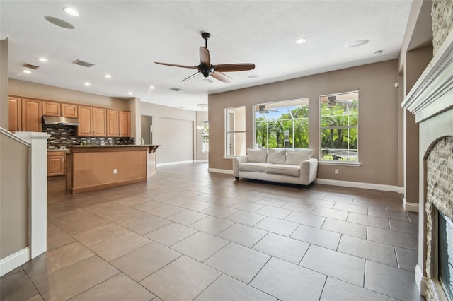 living room featuring recessed lighting, visible vents, a ceiling fan, baseboards, and a glass covered fireplace