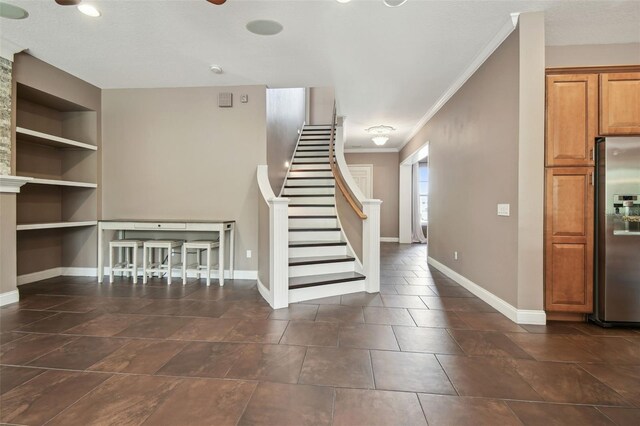 interior space with baseboards, built in features, and crown molding