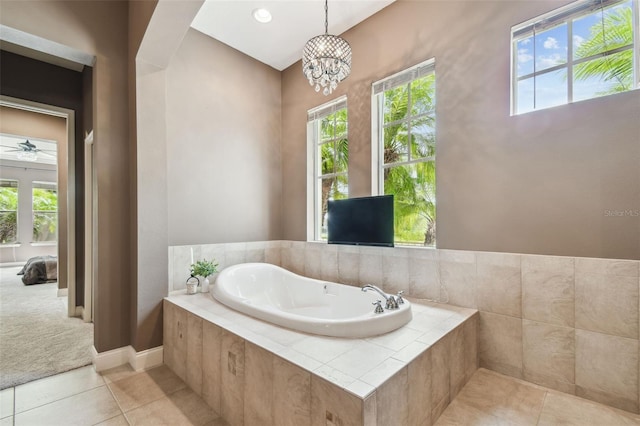 full bath with a bath, tile patterned floors, baseboards, and a notable chandelier