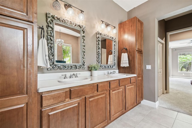 full bathroom featuring double vanity, tile patterned flooring, baseboards, and a sink