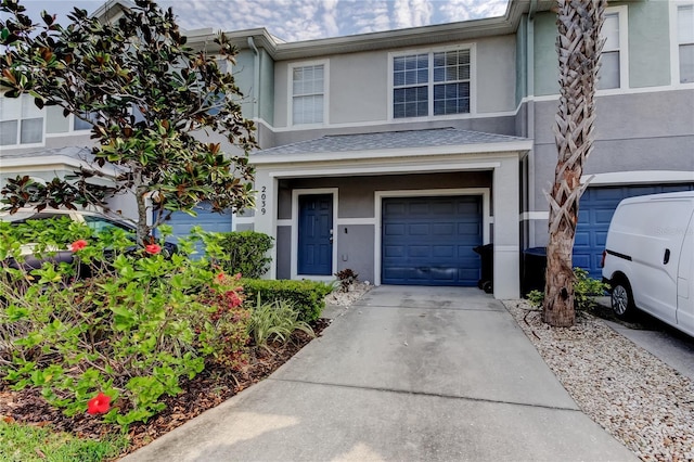 view of front of home with stucco siding, a garage, and driveway