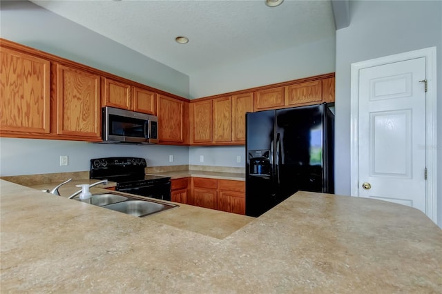 kitchen with brown cabinets, black appliances, light countertops, and a sink