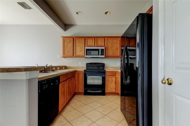 kitchen with light countertops, light tile patterned floors, brown cabinetry, black appliances, and a sink