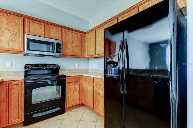 kitchen featuring light tile patterned floors, black appliances, and light countertops