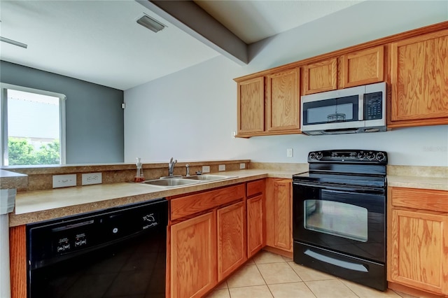 kitchen featuring light tile patterned floors, black appliances, light countertops, and a sink