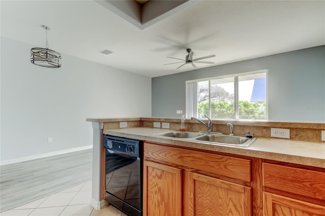 kitchen with a ceiling fan, a sink, light countertops, pendant lighting, and dishwasher