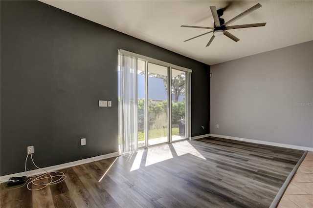 empty room with baseboards, ceiling fan, and wood finished floors