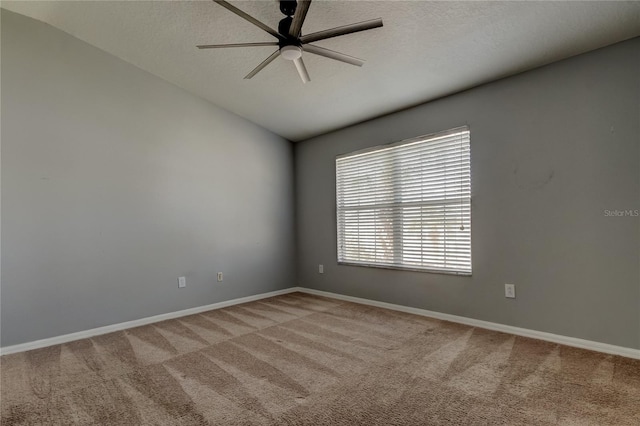 spare room with a ceiling fan, a textured ceiling, carpet flooring, baseboards, and vaulted ceiling