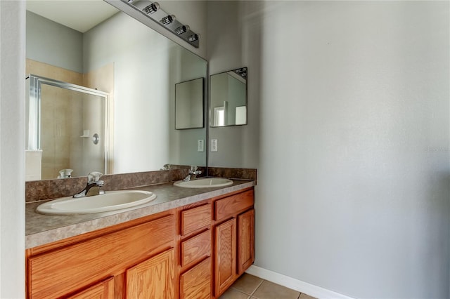 full bathroom featuring tile patterned floors, double vanity, a stall shower, and a sink