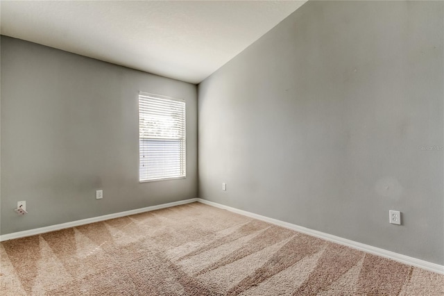 unfurnished room with carpet flooring and baseboards