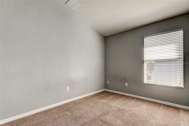 empty room featuring visible vents, baseboards, and light carpet