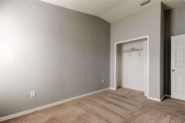 unfurnished bedroom with visible vents, baseboards, vaulted ceiling, carpet floors, and a closet