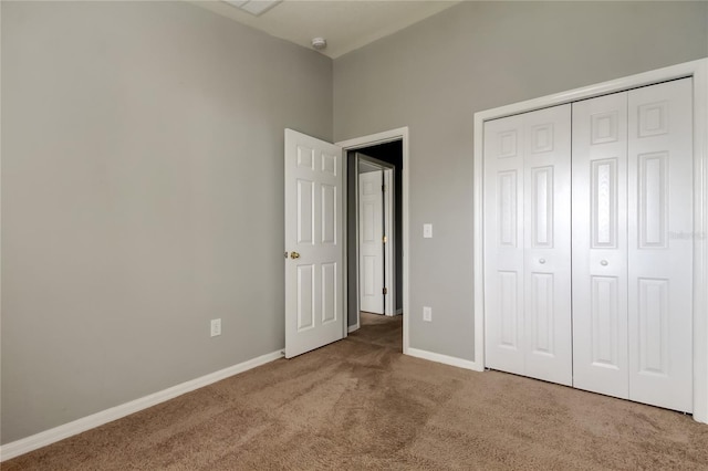 unfurnished bedroom with carpet flooring, baseboards, and a closet