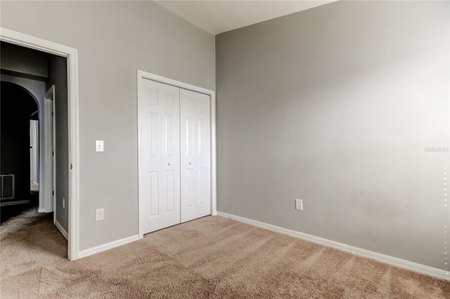 unfurnished bedroom with a closet, visible vents, baseboards, and carpet