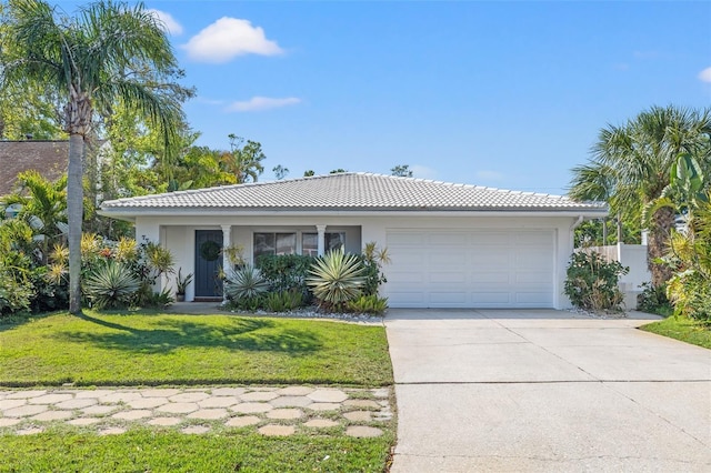 view of front of property with a front yard, driveway, stucco siding, a garage, and a tiled roof