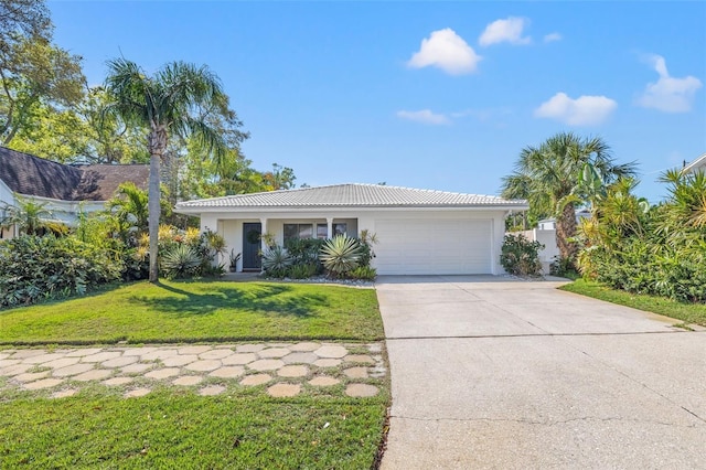 view of front of home featuring a front yard, an attached garage, stucco siding, concrete driveway, and a tile roof