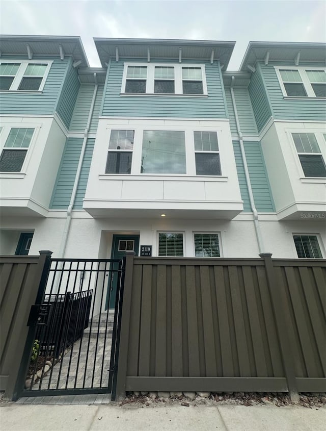 view of front of property featuring a fenced front yard, stucco siding, and a gate