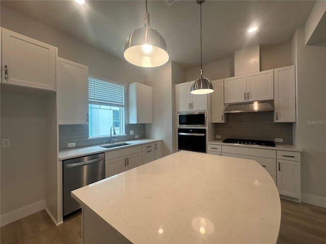 kitchen featuring a sink, black appliances, light countertops, under cabinet range hood, and white cabinetry