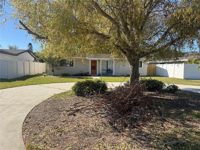 ranch-style house with a front yard, fence, and stucco siding