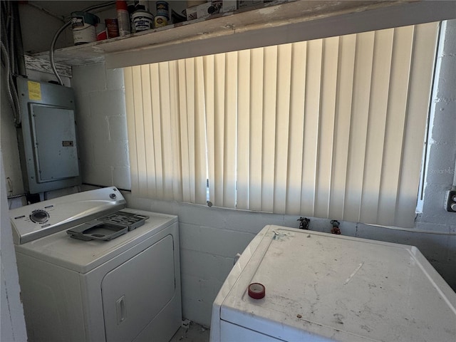 washroom featuring electric panel, concrete block wall, and laundry area