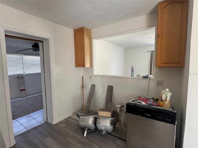 interior space with a ceiling fan, a textured ceiling, baseboards, dishwasher, and dark wood-style flooring