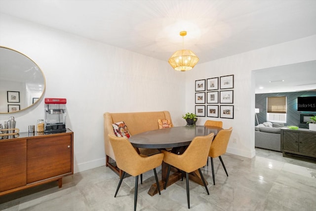 dining area with an inviting chandelier, finished concrete flooring, and baseboards