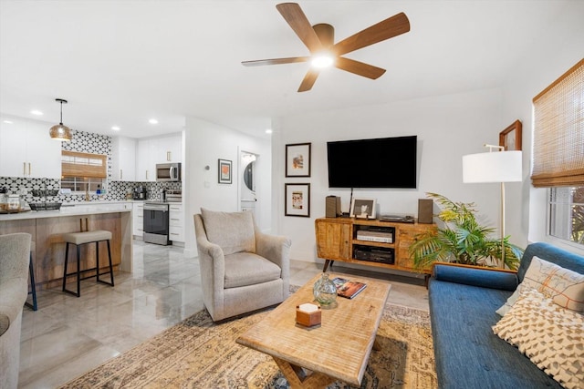 living area with recessed lighting, marble finish floor, and a ceiling fan