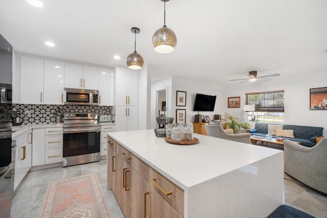 kitchen with open floor plan, decorative backsplash, stainless steel appliances, a ceiling fan, and modern cabinets