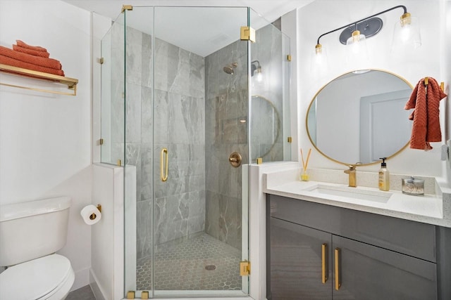 bathroom featuring toilet, a stall shower, and vanity