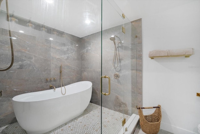 full bath with a soaking tub, tile walls, and a stall shower