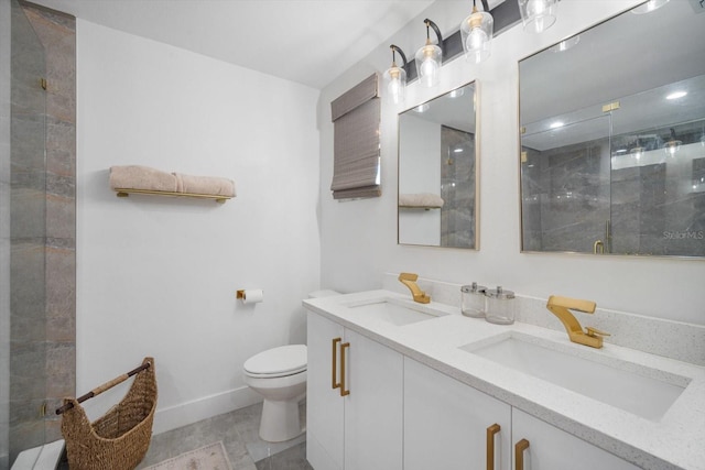 bathroom with a sink, toilet, double vanity, and a shower stall