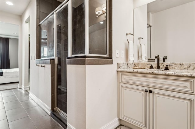 full bathroom featuring tile patterned flooring, a stall shower, vanity, and baseboards