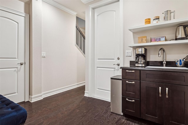 bar featuring dark wood-style floors, baseboards, and a sink