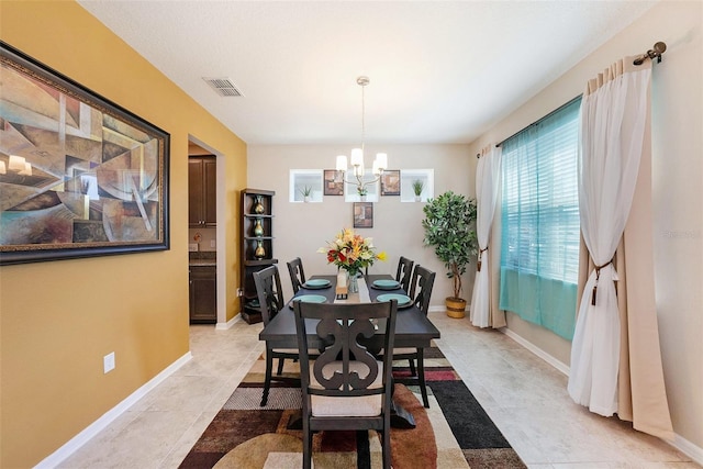 dining room with a notable chandelier, baseboards, and visible vents