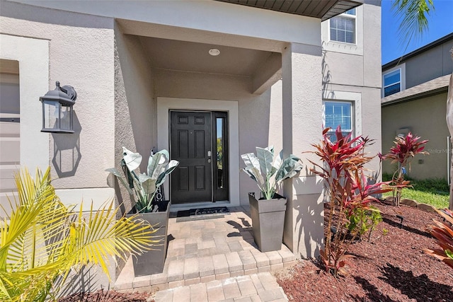 entrance to property featuring stucco siding