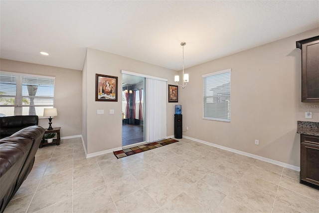 interior space with a wealth of natural light, baseboards, a notable chandelier, and recessed lighting