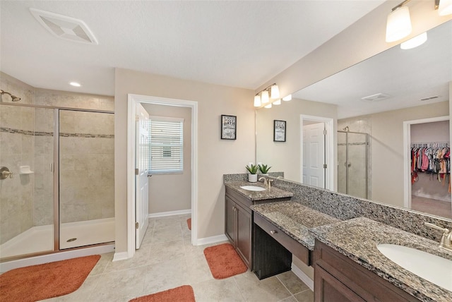 full bath featuring a stall shower, baseboards, visible vents, and a sink