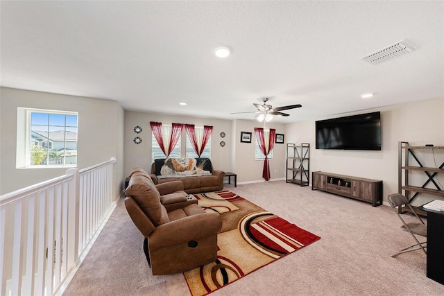 carpeted living room featuring plenty of natural light, baseboards, visible vents, and ceiling fan