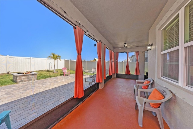 view of patio with a fenced backyard, a ceiling fan, and an outdoor fire pit