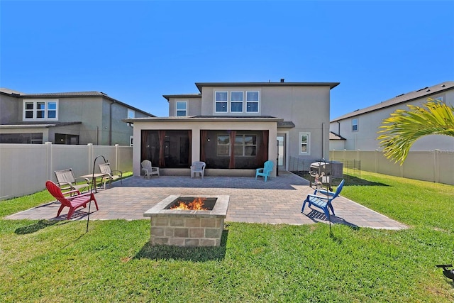 rear view of house with a fenced backyard, a sunroom, a fire pit, a patio area, and a lawn