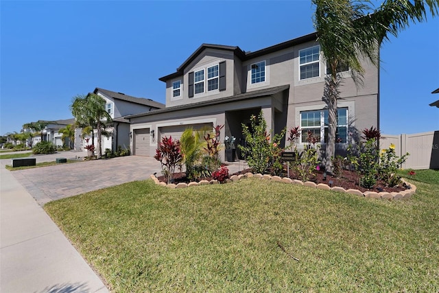 view of front of house featuring fence, driveway, stucco siding, a front lawn, and a garage