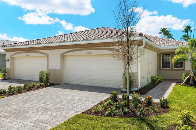 20411 Symphony Pl, Venice, FL 34293 - view of front facade featuring a garage, stucco siding, a tiled roof, and decorative driveway