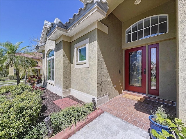 entrance to property featuring stucco siding