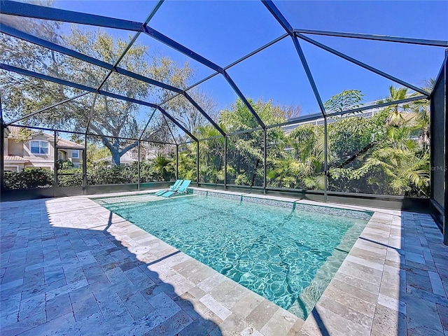 outdoor pool with glass enclosure and a patio