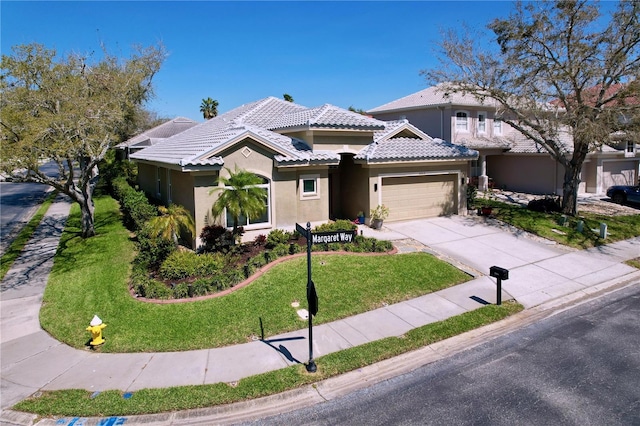 view of front facade with stucco siding, a front lawn, concrete driveway, a garage, and a tiled roof