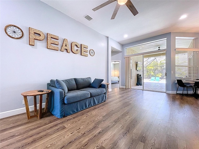 living room with visible vents, baseboards, a ceiling fan, and wood finished floors