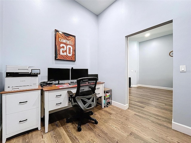 home office with baseboards and light wood finished floors