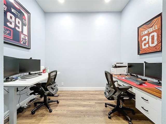 office area with light wood-style floors and baseboards