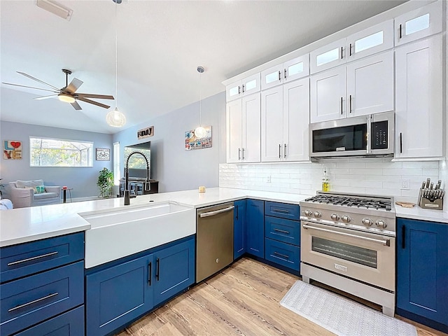 kitchen with blue cabinets, a ceiling fan, a sink, stainless steel appliances, and light countertops